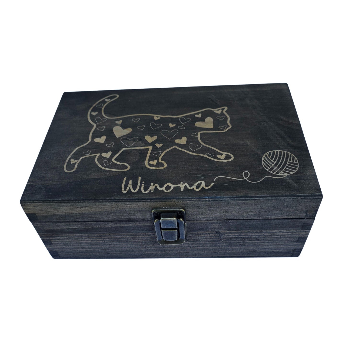 Black box with a latch. A cat with a heart with a ball of yarn. The cat appears to be moving towards the ball of yarn. Under the cat is the cat's name